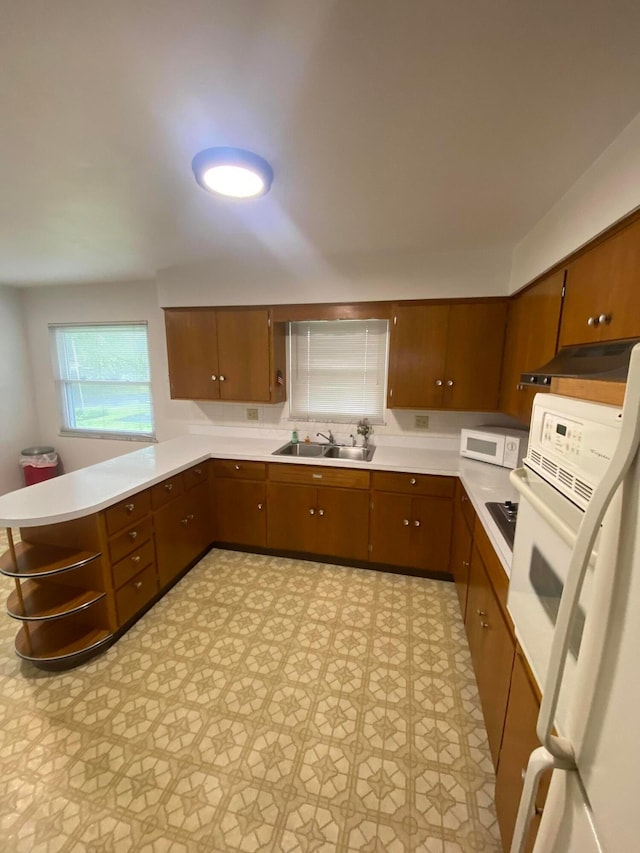 1616 Sale Rd, Columbus, OH 43224 - kitchen with a sink, white appliances, a peninsula, light countertops, and light floors