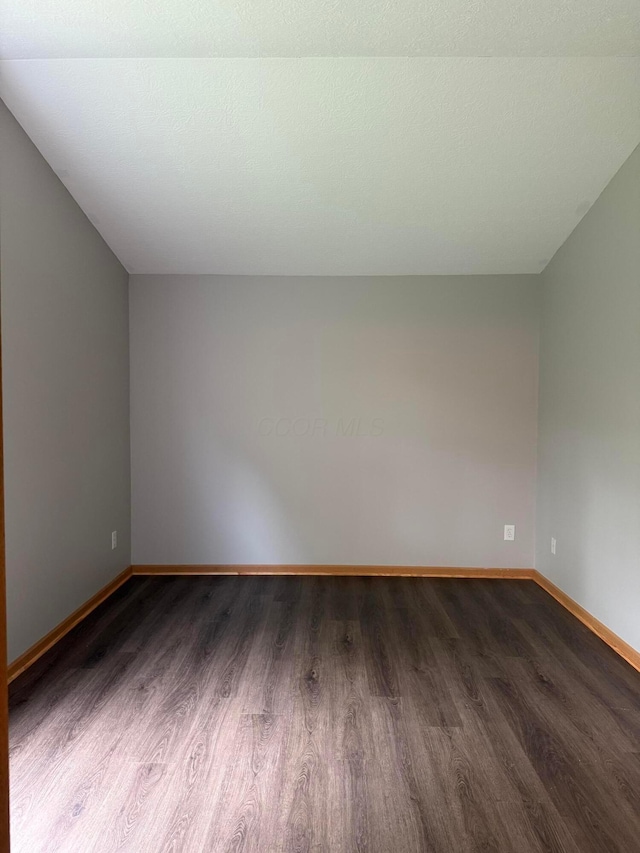 unfurnished room featuring wood finished floors and baseboards