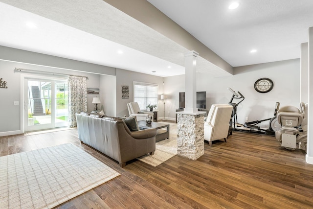 living room with dark wood-style flooring, decorative columns, recessed lighting, and baseboards