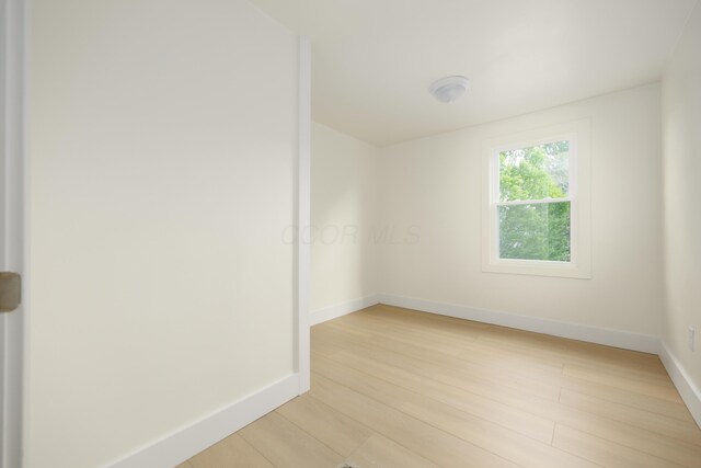 spare room with light wood-style floors and baseboards