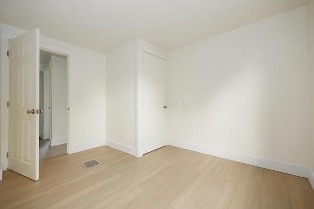 spare room with light wood finished floors and baseboards