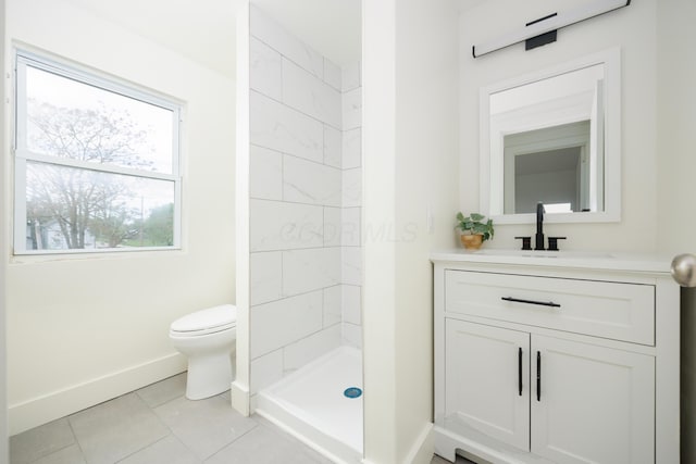 bathroom with baseboards, toilet, a stall shower, vanity, and tile patterned flooring
