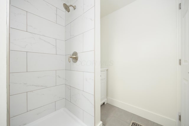 full bathroom with a shower stall, tile patterned flooring, and baseboards