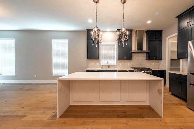 959 Hudson Xing, Columbus, OH 43212 - kitchen featuring wall chimney range hood, a chandelier, decorative backsplash, light countertops, and recessed lighting
