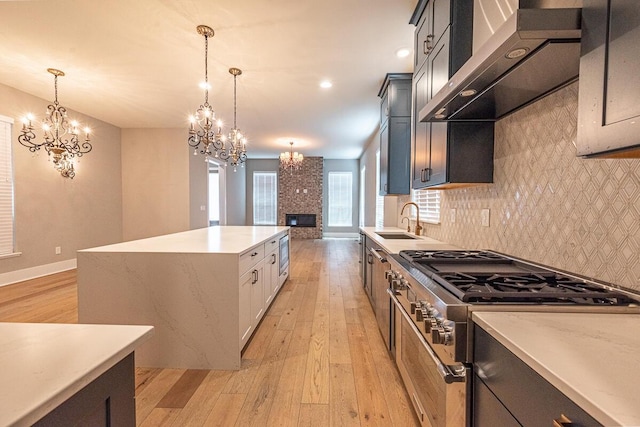 959 Hudson Xing, Columbus, OH 43212 - kitchen featuring gas stove, wall chimney range hood, a sink, a chandelier, and recessed lighting