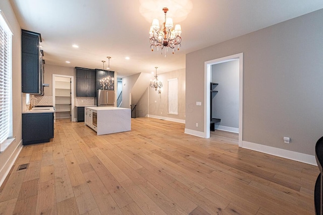 959 Hudson Xing, Columbus, OH 43212 - kitchen with a chandelier, light countertops, a center island, baseboards, and recessed lighting