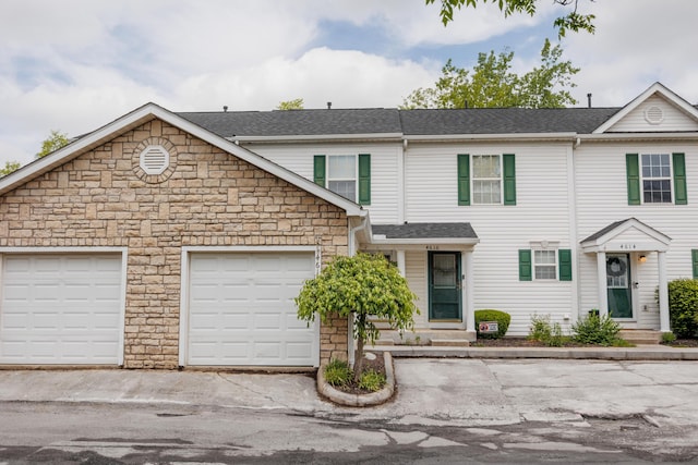 4618 Parrau Dr Unit 72B, Columbus, OH 43228 - view of property with stone siding, a shingled roof, an attached garage, and entry steps