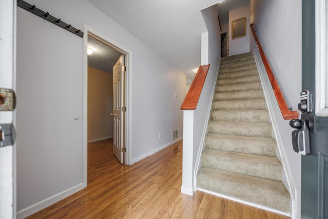 4618 Parrau Dr Unit 72B, Columbus, OH 43228 - stairs featuring baseboards, wood finished floors, and a textured ceiling