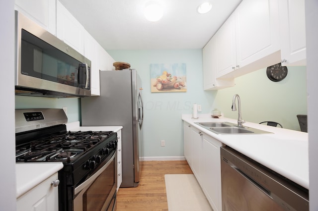 4618 Parrau Dr Unit 72B, Columbus, OH 43228 - kitchen featuring appliances with stainless steel finishes, a sink, light wood-style flooring, and white cabinetry