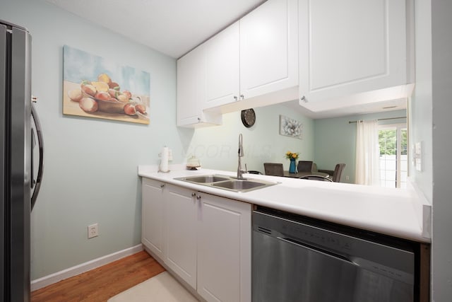 4618 Parrau Dr Unit 72B, Columbus, OH 43228 - kitchen with appliances with stainless steel finishes, a sink, light wood-style floors, and white cabinetry