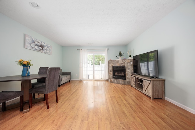 4618 Parrau Dr Unit 72B, Columbus, OH 43228 - living area with light wood-style flooring, a fireplace, baseboards, and a textured ceiling