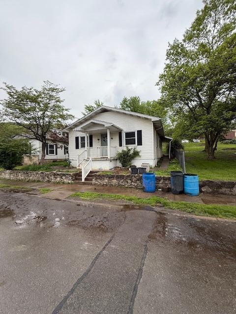 bungalow featuring a porch and driveway