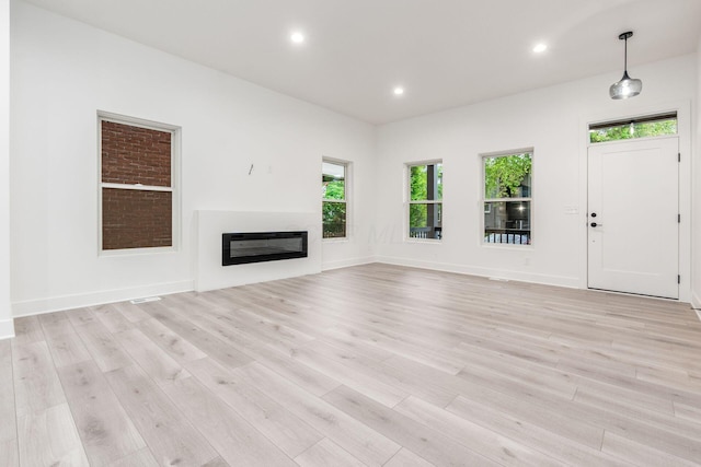 1177 Franklin Ave, Columbus, OH 43205 - unfurnished living room featuring light wood finished floors, recessed lighting, a glass covered fireplace, and baseboards