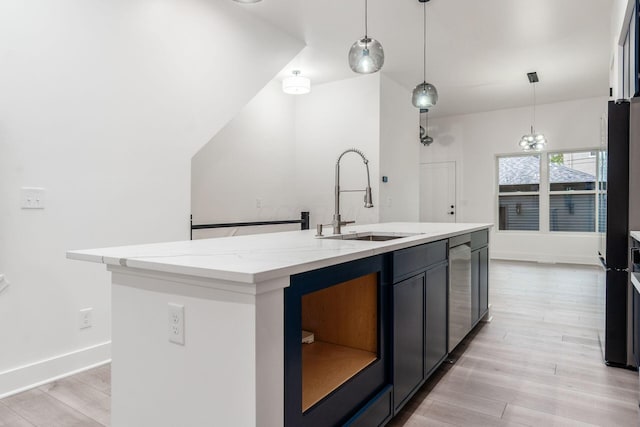 1177 Franklin Ave, Columbus, OH 43205 - kitchen featuring a sink, a kitchen island with sink, light wood-style floors, light stone countertops, and hanging light fixtures