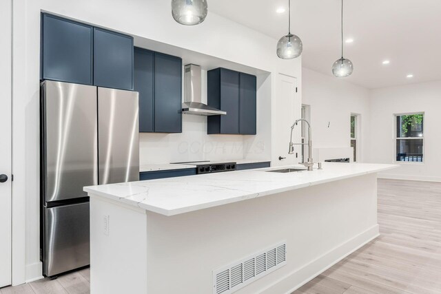 1177 Franklin Ave, Columbus, OH 43205 - kitchen featuring freestanding refrigerator, wall chimney exhaust hood, a sink, blue cabinetry, and range with electric stovetop