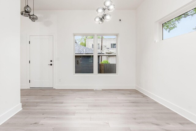 1177 Franklin Ave, Columbus, OH 43205 - unfurnished dining area featuring healthy amount of natural light, a chandelier, light wood-type flooring, and baseboards
