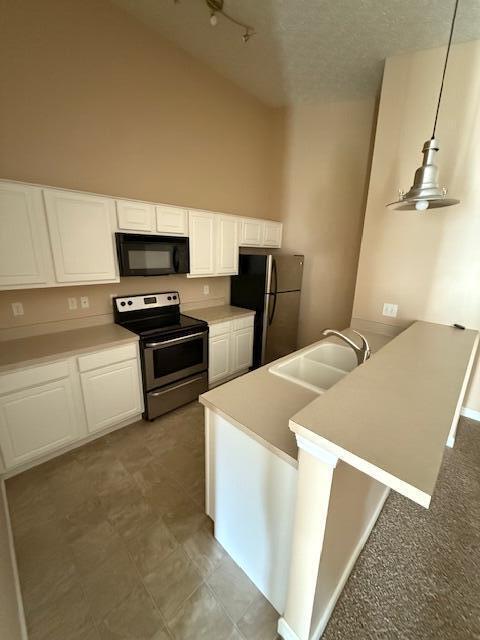6983 Remsen Dr Unit 77A, Canal Winchester, OH 43110 - kitchen with stainless steel appliances, a sink, a peninsula, white cabinets, and lofted ceiling