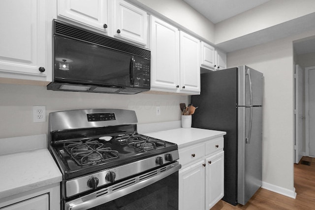 2999 Glenloch Cir, Dublin, OH 43017 - kitchen with stainless steel appliances, light wood-type flooring, white cabinetry, and baseboards