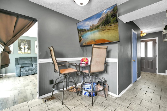 3072 Bocastle Ct, Reynoldsburg, OH 43068 - dining room with a textured ceiling, wainscoting, tile patterned floors, and baseboards