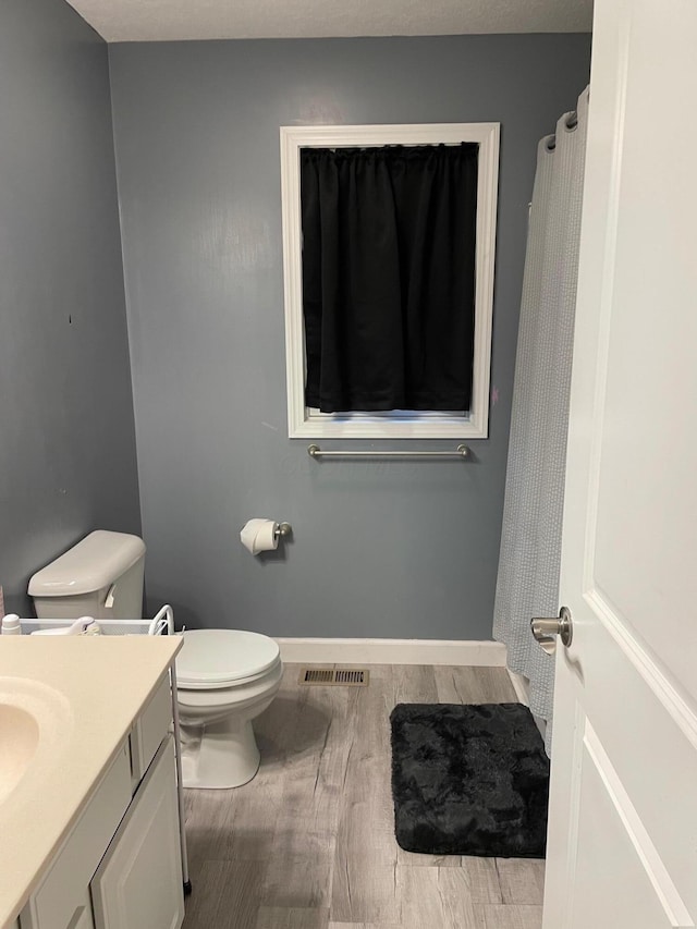 7719 Bear Run Rd, Logan, OH 43138 - full bathroom with wood finished floors, toilet, vanity, and baseboards