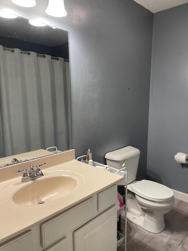 7719 Bear Run Rd, Logan, OH 43138 - bathroom featuring toilet, vanity, wood finished floors, and baseboards