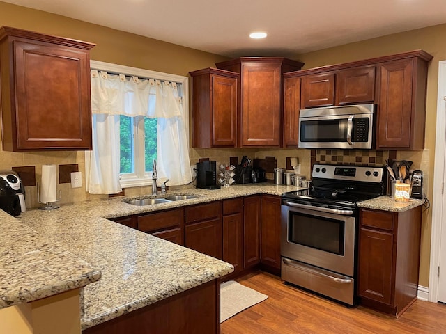 7719 Bear Run Rd, Logan, OH 43138 - kitchen featuring appliances with stainless steel finishes, a sink, light wood finished floors, backsplash, and recessed lighting