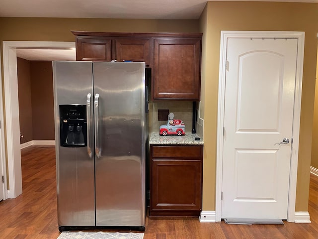 7719 Bear Run Rd, Logan, OH 43138 - kitchen featuring stainless steel fridge with ice dispenser, wood finished floors, light stone counters, and baseboards