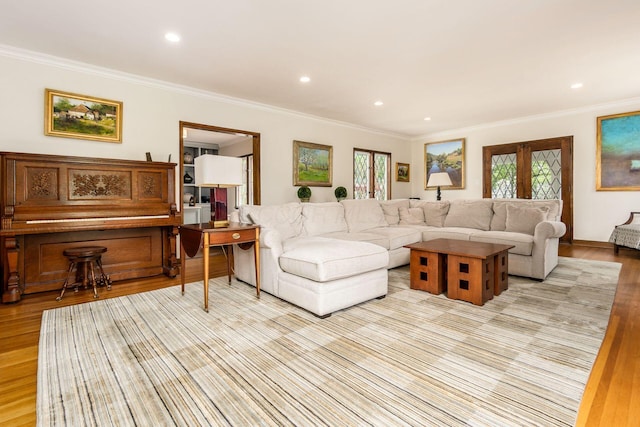 living room with light wood-style floors, ornamental molding, and recessed lighting