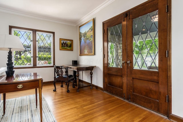 home office featuring wood finished floors, healthy amount of natural light, ornamental molding, baseboards, and french doors