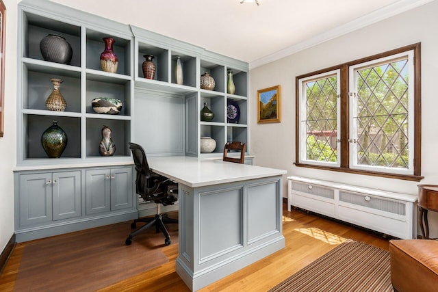 office space with built in study area, wood finished floors, crown molding, baseboards, and built in features