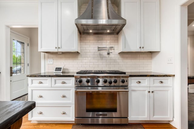 kitchen featuring high end range, island range hood, and white cabinets