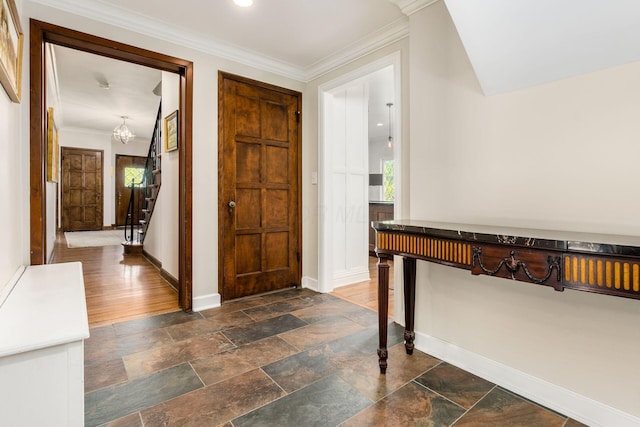 entrance foyer with baseboards, stairway, stone tile flooring, a chandelier, and ornamental molding