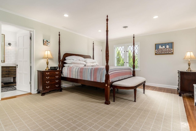 bedroom with ornamental molding, baseboards, light wood-style floors, recessed lighting, and connected bathroom
