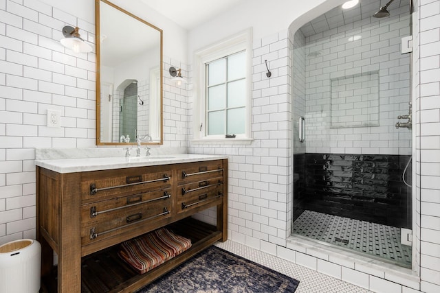 bathroom with tile walls, a stall shower, and vanity