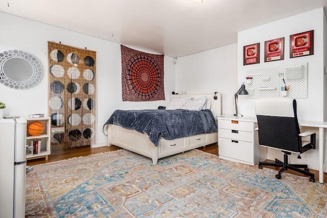bedroom featuring wood finished floors and an office area