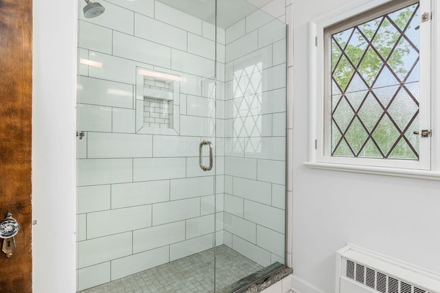 full bath featuring plenty of natural light, a stall shower, and baseboards
