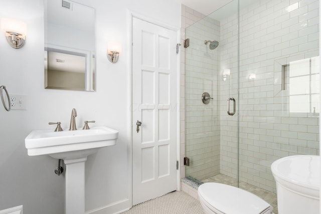 bathroom featuring toilet, a shower stall, and tile patterned flooring
