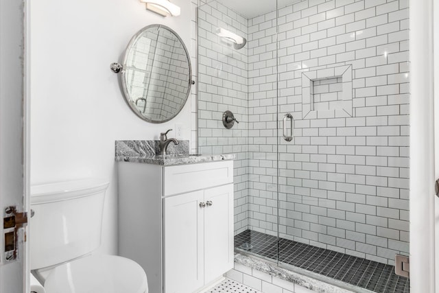full bath featuring a stall shower, toilet, and vanity