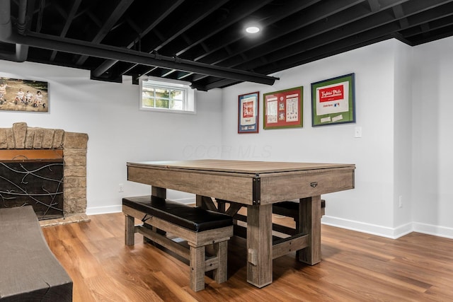 dining area featuring baseboards, wood finished floors, and a fireplace