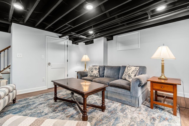 living area featuring stairs, wood finished floors, and baseboards