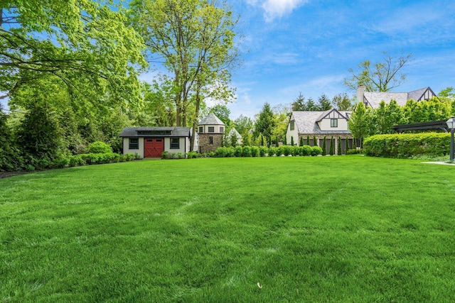 view of green lawn featuring an outbuilding