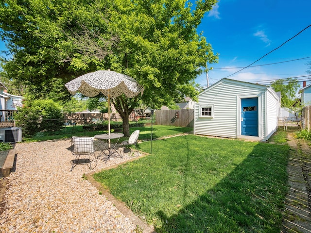 view of yard featuring an outdoor structure, a shed, and central AC