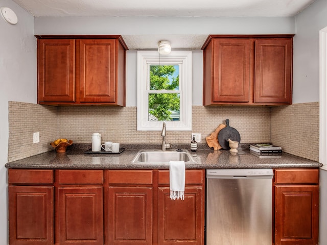 kitchen featuring stainless steel dishwasher, a sink, dark countertops, and backsplash