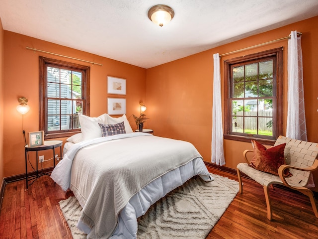bedroom with wood-type flooring and baseboards