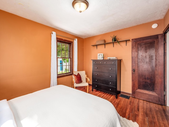 bedroom featuring wood finished floors and baseboards