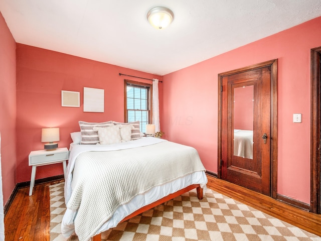 bedroom with wood finished floors and baseboards
