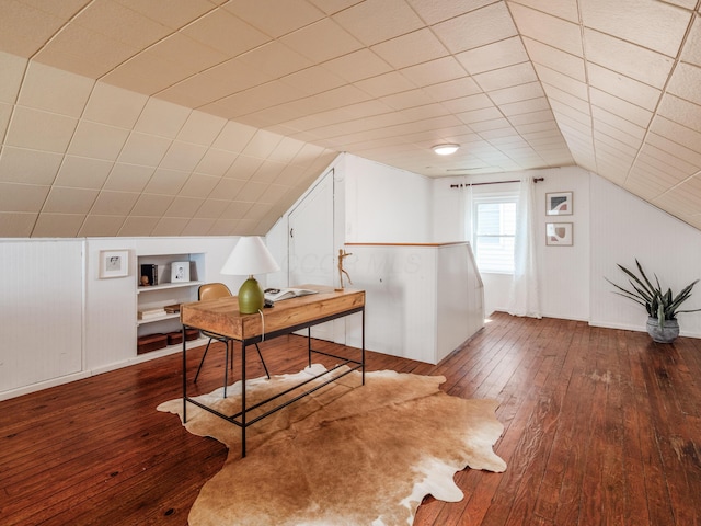 home office featuring hardwood / wood-style floors, vaulted ceiling, and built in features