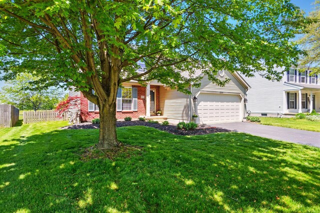 8380 Squad Dr, Galloway, OH 43119 - obstructed view of property with a garage, asphalt driveway, and brick siding