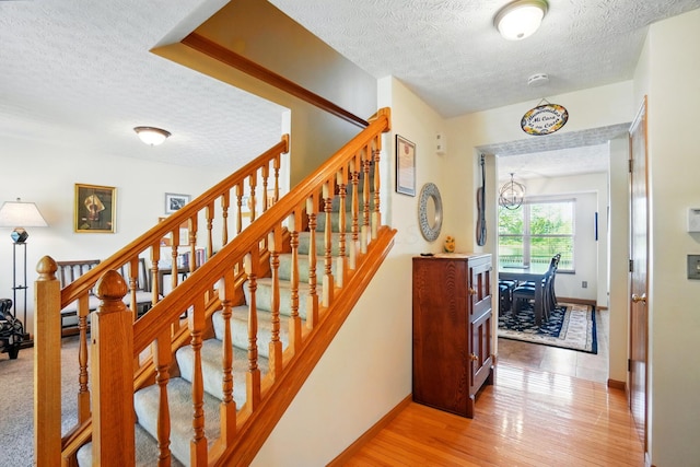 8380 Squad Dr, Galloway, OH 43119 - staircase with a textured ceiling, baseboards, wood finished floors, and a chandelier