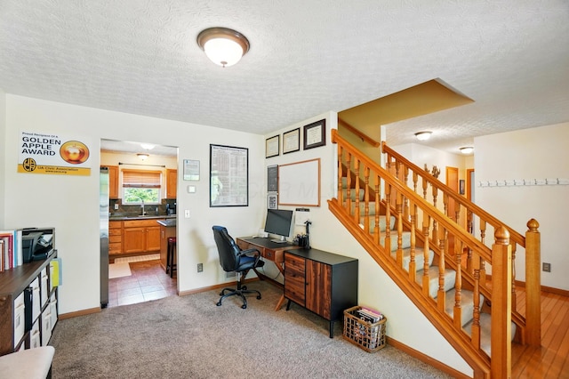 8380 Squad Dr, Galloway, OH 43119 - office area featuring a sink, a textured ceiling, baseboards, and light colored carpet